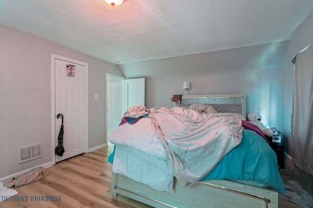 14725 Agnes Ave, Eastpointe, MI 48021 - bedroom featuring lofted ceiling, wood finished floors, visible vents, baseboards, and a textured ceiling