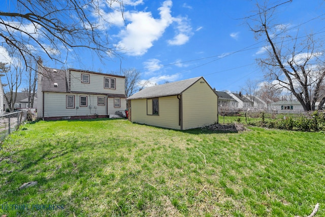 14725 Agnes Ave, Eastpointe, MI 48021 - rear view of property with a fenced backyard, an outdoor structure, and a lawn