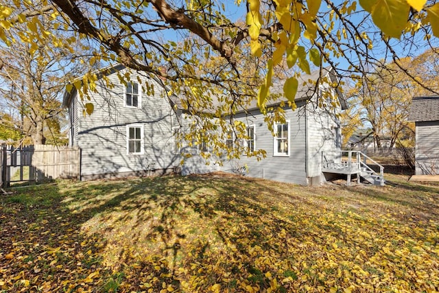 exterior space with fence, a wooden deck, and a yard