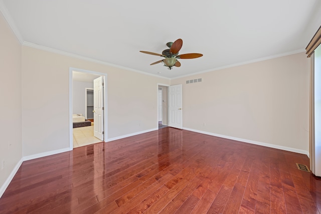 unfurnished bedroom with visible vents, baseboards, crown molding, and wood finished floors