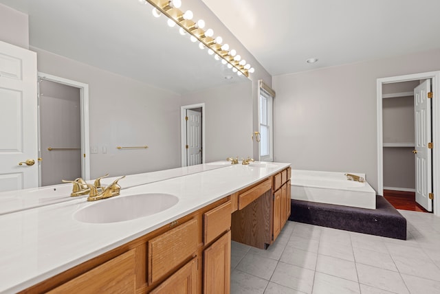 bathroom with double vanity, tile patterned floors, a sink, and a garden tub