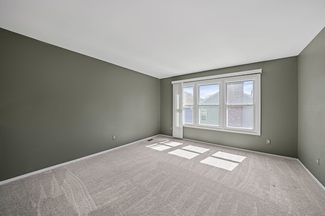 carpeted spare room with baseboards