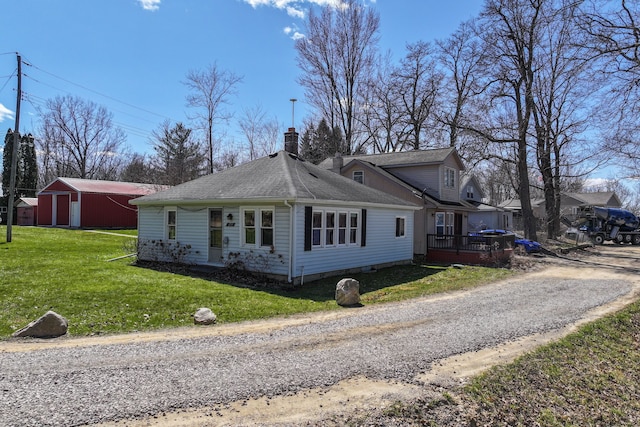 3931 S Shore Dr, Lapeer, MI 48446 - view of front of house featuring a chimney, a front lawn, an outdoor structure, and a shingled roof