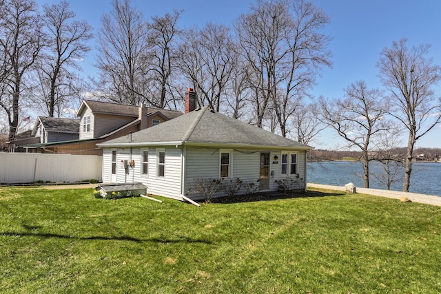 3931 S Shore Dr, Lapeer, MI 48446 - view of home's exterior with fence, a chimney, a yard, and a water view