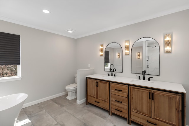 bathroom featuring double vanity, toilet, a sink, crown molding, and a soaking tub