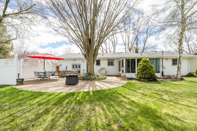 1601 Barbara Ann Dr, Stevensville, MI 49127 - rear view of property featuring fence, a patio area, a lawn, an outdoor fire pit, and a sunroom