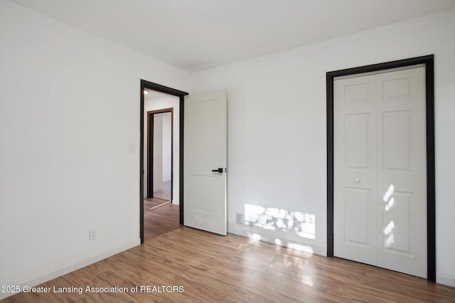 unfurnished bedroom with wood finished floors and baseboards