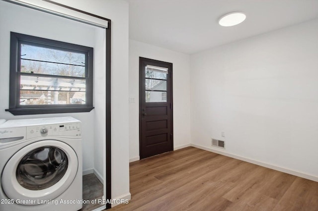 clothes washing area with wood finished floors, laundry area, baseboards, washer / clothes dryer, and visible vents