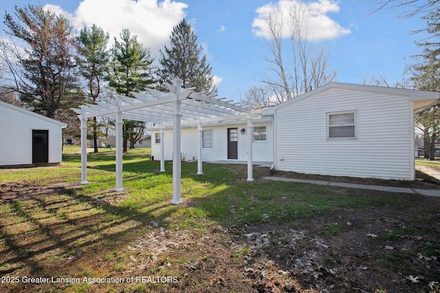 back of property featuring a pergola and a yard