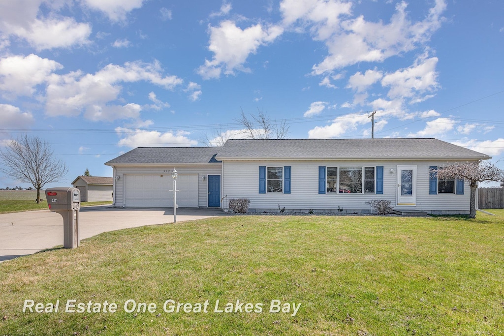 ranch-style house with an attached garage, driveway, and a front lawn