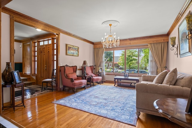 living room featuring an inviting chandelier, crown molding, and wood finished floors