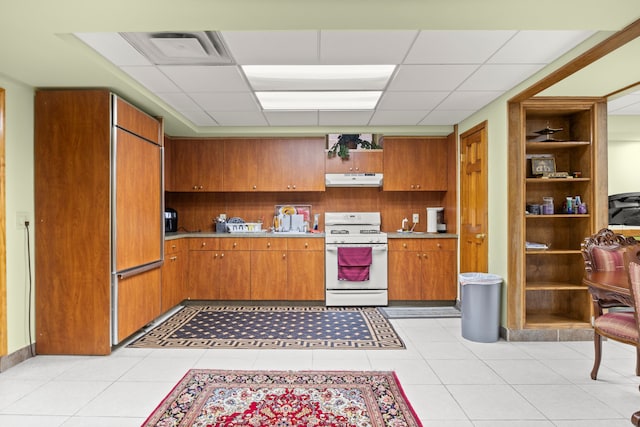 kitchen featuring brown cabinets, white gas stove, visible vents, and light countertops