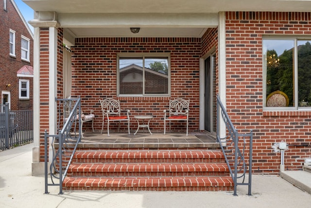 view of exterior entry featuring brick siding