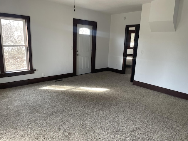 carpeted foyer with baseboards and visible vents