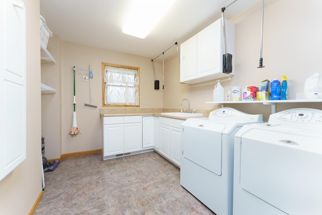 laundry area featuring washer and clothes dryer, baseboards, a sink, and cabinet space