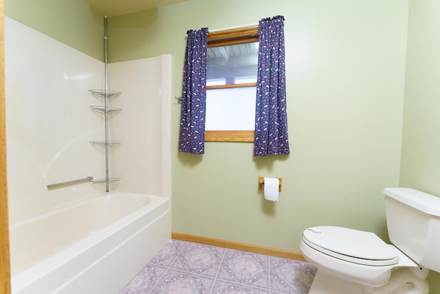 bathroom featuring shower / bathtub combination, baseboards, tile patterned flooring, and toilet