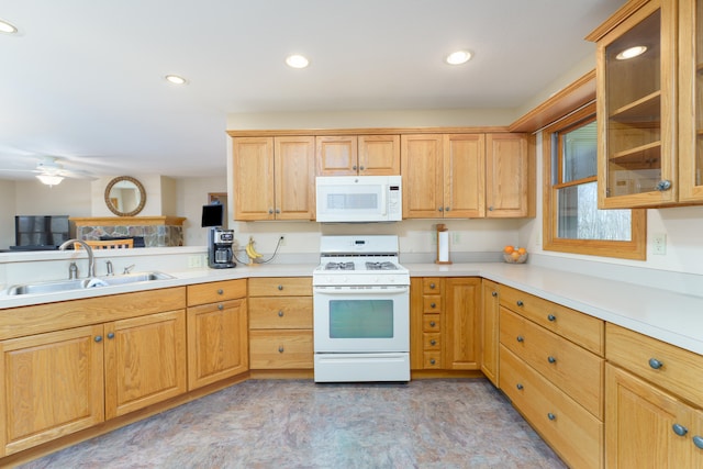 kitchen with a sink, white appliances, glass insert cabinets, ceiling fan, and light countertops
