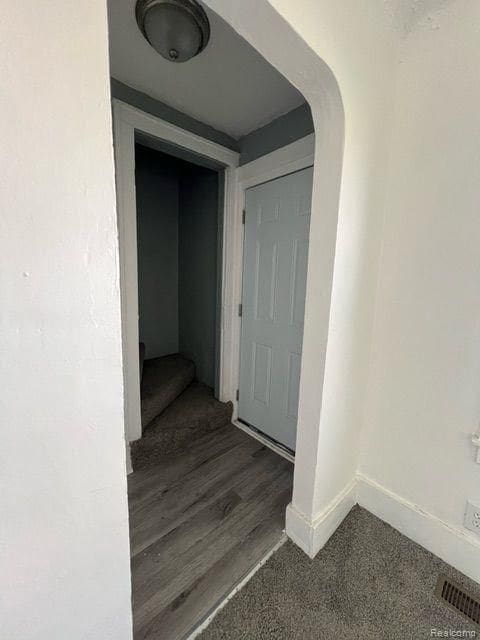 interior space with arched walkways, baseboards, and visible vents
