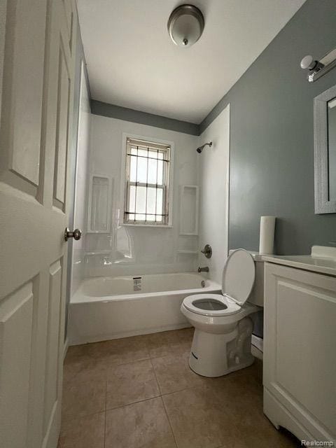 bathroom featuring toilet, vanity, tile patterned floors, and shower / tub combination