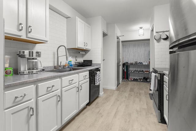 kitchen featuring white cabinets, a sink, backsplash, and appliances with stainless steel finishes