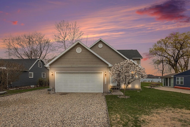 view of front of home featuring concrete driveway, a yard, and a garage