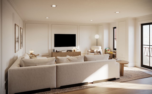 living area featuring ornamental molding, a decorative wall, and recessed lighting
