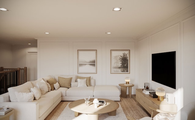 living area featuring a decorative wall, recessed lighting, and crown molding