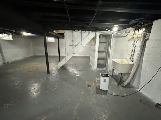 below grade area with stairway and a sink