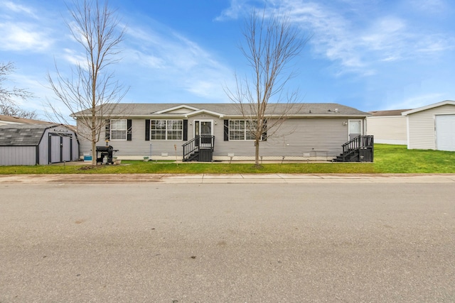 single story home with an outdoor structure, crawl space, a front lawn, and a storage shed