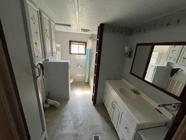 full bathroom with toilet, vanity, a textured ceiling, and visible vents