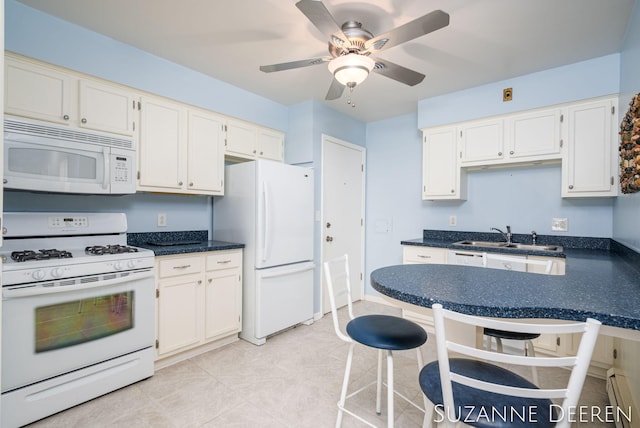 kitchen with dark countertops, baseboard heating, and white appliances