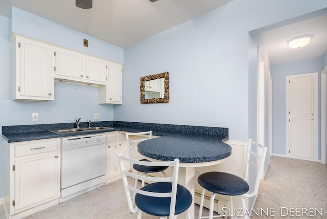 kitchen featuring white cabinets, dark countertops, white dishwasher, and a sink