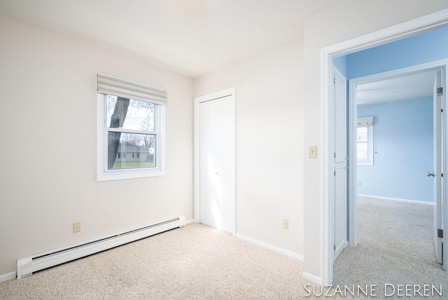 unfurnished bedroom featuring a baseboard radiator, carpet floors, baseboards, and a closet