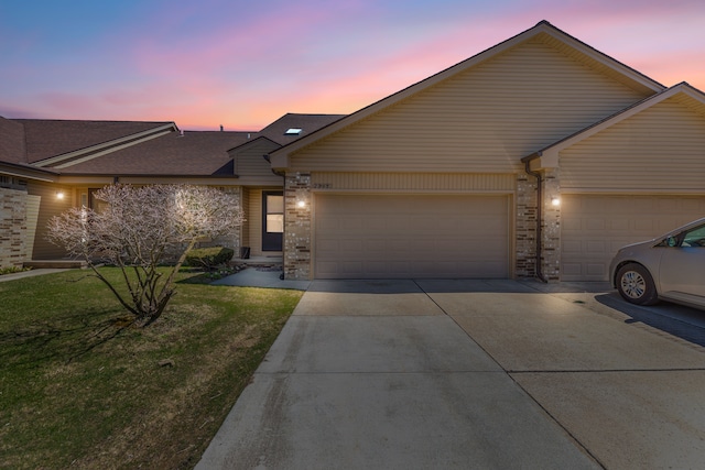 view of front of home featuring a front lawn, driveway, and a garage