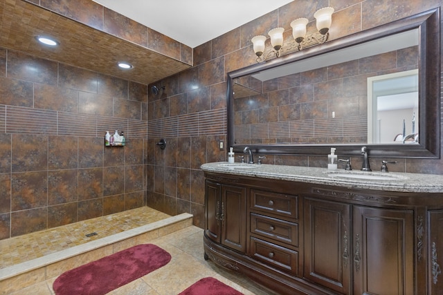 bathroom with double vanity, tile walls, tiled shower, and a sink