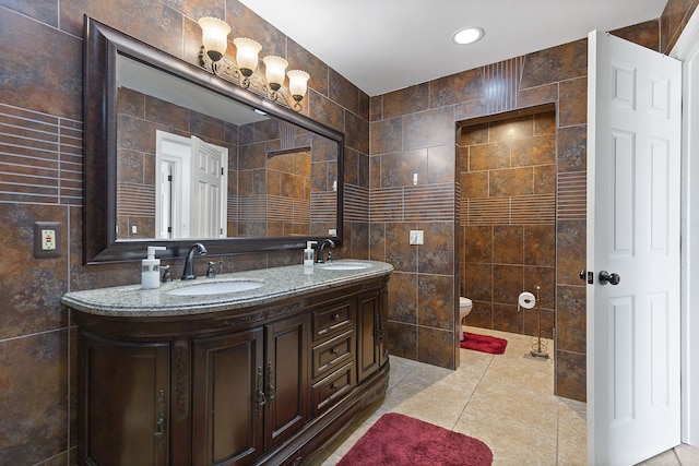 bathroom featuring tile walls, a sink, double vanity, and toilet