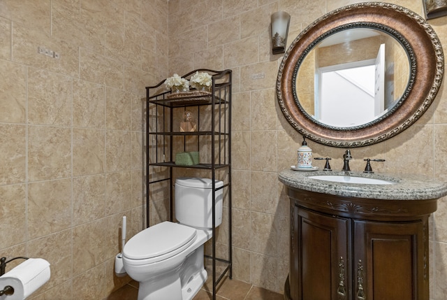 bathroom featuring tile walls, toilet, and vanity
