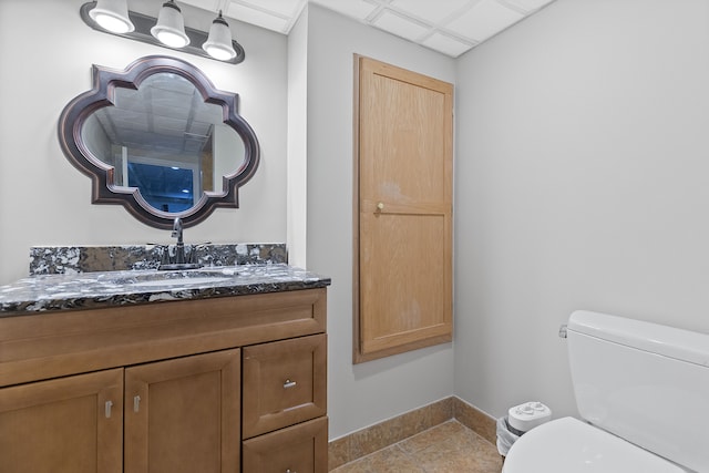 bathroom featuring tile patterned flooring, vanity, toilet, and baseboards