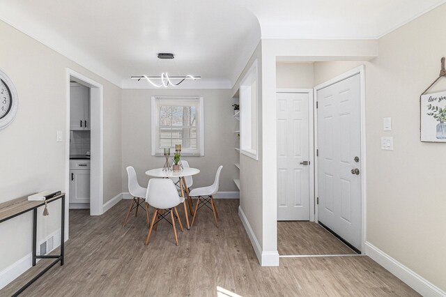 8911 Plainview Ave, Detroit, MI 48228 - dining area featuring light wood-type flooring, baseboards, and a chandelier