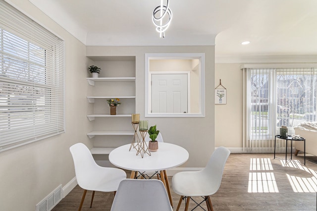 8911 Plainview Ave, Detroit, MI 48228 - dining area featuring wood finished floors, visible vents, built in shelves, and baseboards