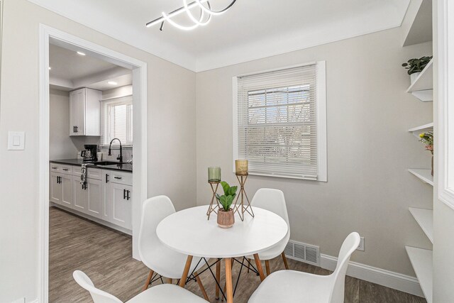 8911 Plainview Ave, Detroit, MI 48228 - dining area featuring a chandelier, wood finished floors, visible vents, and baseboards