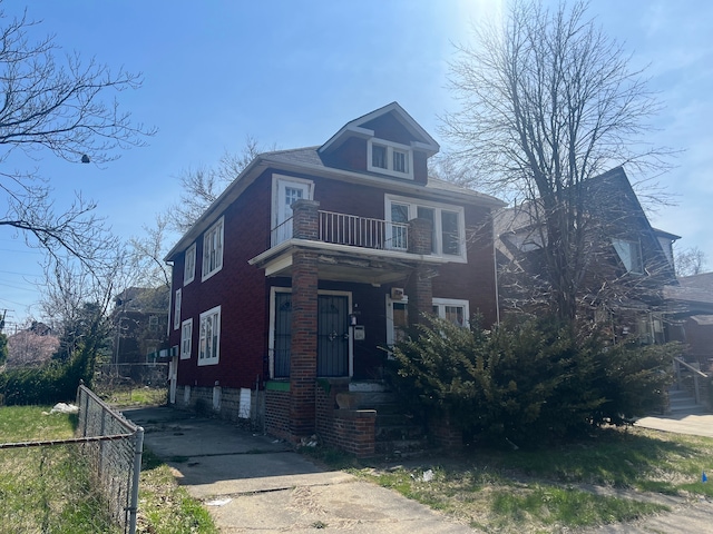 american foursquare style home featuring fence and a balcony