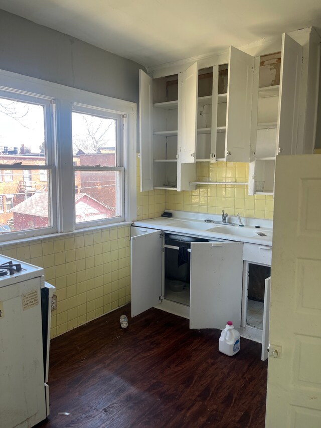 kitchen with dark wood-style flooring, white cabinetry, stove, open shelves, and light countertops