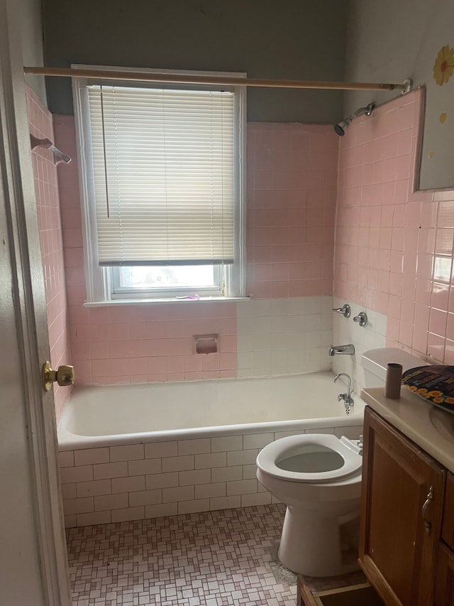 bathroom with vanity, tile walls, tiled shower / bath combo, toilet, and tile patterned flooring