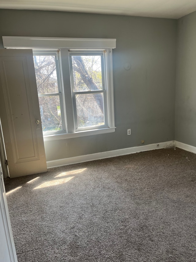 carpeted empty room featuring baseboards and a healthy amount of sunlight