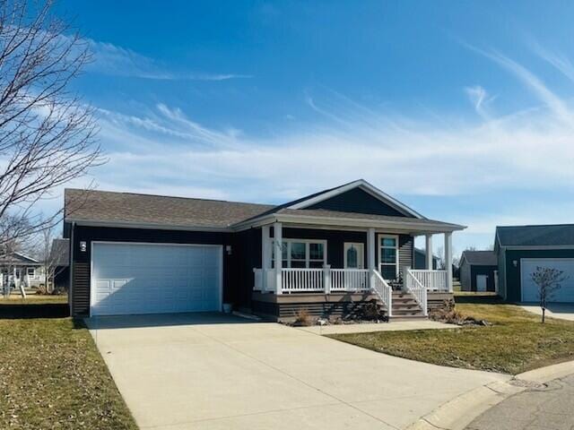 5652 Kingsley Dr NE, Rockford, MI 49341 - single story home featuring a front lawn, driveway, a garage, and covered porch