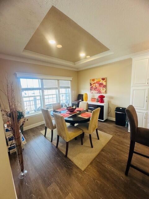 5652 Kingsley Dr NE, Rockford, MI 49341 - dining area with a tray ceiling, wood finished floors, baseboards, and ornamental molding