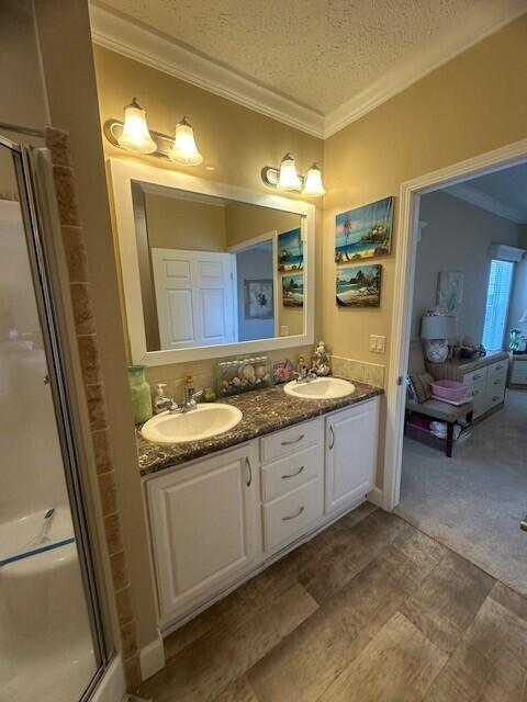 5652 Kingsley Dr NE, Rockford, MI 49341 - bathroom with crown molding, a sink, double vanity, and a stall shower
