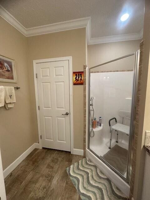5652 Kingsley Dr NE, Rockford, MI 49341 - bathroom featuring a shower stall, baseboards, ornamental molding, and wood finished floors