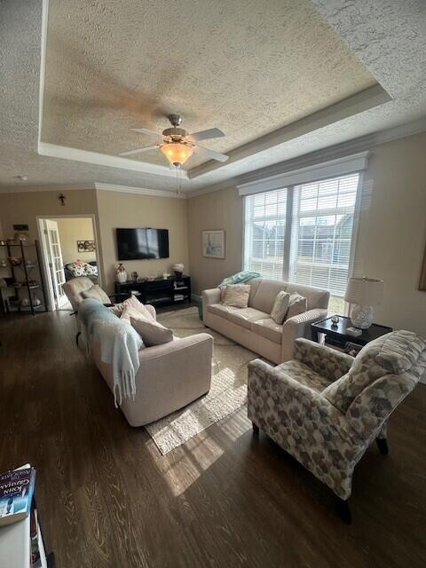 5652 Kingsley Dr NE, Rockford, MI 49341 - living area with a ceiling fan, wood finished floors, a textured ceiling, a tray ceiling, and ornamental molding